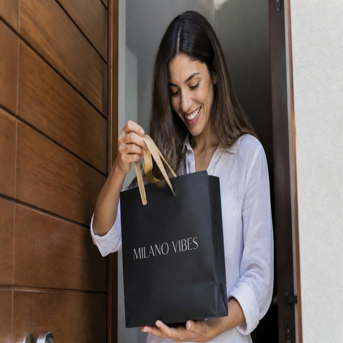 Clienta feliz recibiendo su pedido Milano Vibes con bolsa brandeada
